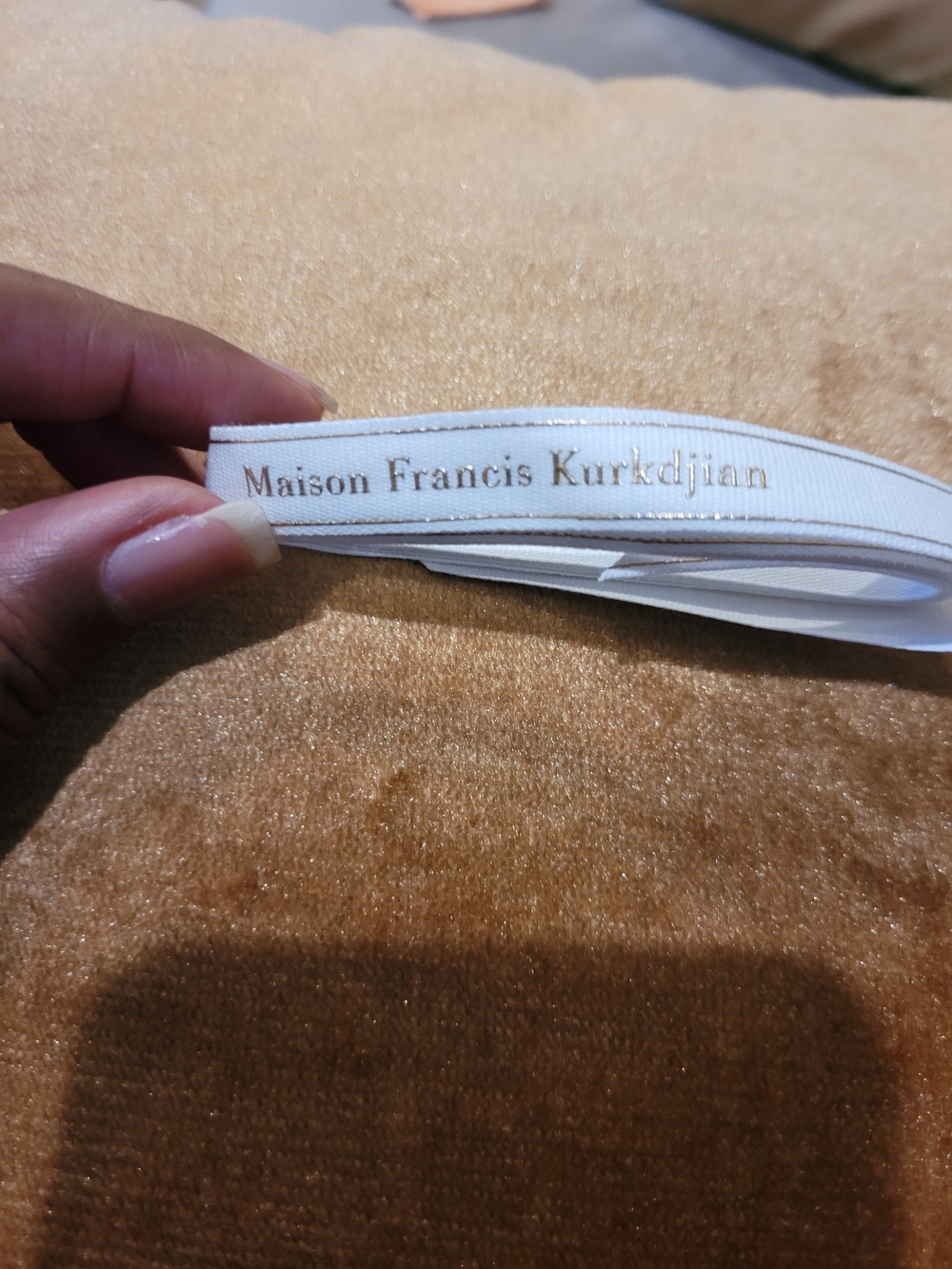 Maison Francis Kurkdjian White Ribbon with Gold Text.